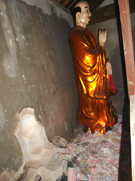 Tiền lẻ được vứt vô tội vạ vào các khám rồng, chân tượng và nhét lên tay, lên người các vị tôn giả trong chùa.