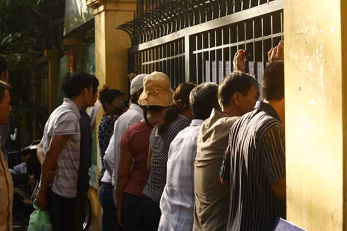 Nhiều phụ huynh sốt ruột đứng ngồi không yên và liên tục ngó qua tường rào vào trong ngóng tin con.