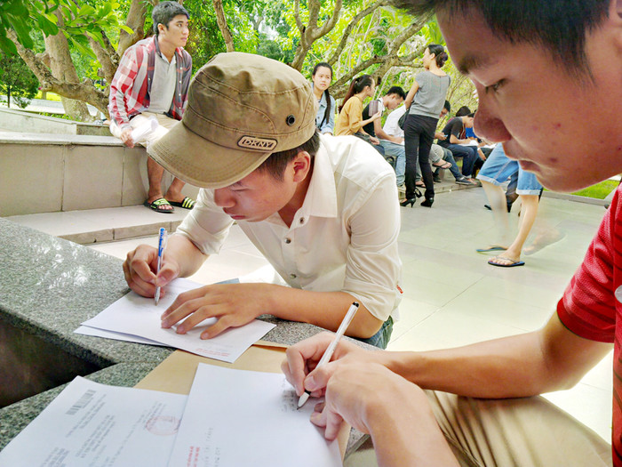 Thí sinh Nguyễn Tài Thăng (áo đỏ) loay hoay viết nguyện vọng để nộp trong sáng nay. Thí sinh Nguyễn Tài Thăng (áo đỏ) loay hoay viết nguyện vọng để nộp trong sáng nay.