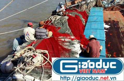 Trong khi tàu đang cố vượt sóng lớn thì trên mũi tàu các thuyền viên vẫn miệt mài vá lưới chuẩn bị cho chuyến đánh cá đầu tiên (ảnh Xuân Hòa)