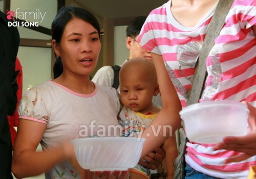 Một bà mẹ bế con đi nhận cháo từ thiện. Xem thêm: 13 lời khuyên để bạn có giấc ngủ sâu