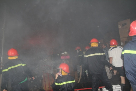 Nhận được tin báo, lực lượng PCCC Nghệ An đã điều 10 xe cứu hoả cùng hàng chục chiến sĩ đến địa điểm xảy ra cháy. Mặc dù có mặt kịp thời và đã tìm mọi cách dập tắt đám cháy nhưng do kho hàng chứa nhiều đồ, hàng hóa hầu hết là đồ mới nhập về còn nguyên đai kiện thùng cát tông và xốp, kho lại kín nên khói bao trùm cả kho hàng khiến công tác chữa cháy gặp nhiều khó khăn. Ảnh: Hàng chục lính cứu hoả đã được điều động đến hiện trường.