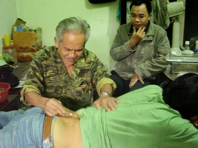 Phòng khám chữa bệnh của thầy Sắt (số 65 đường CMT8, thị trấn Tứ Hạ, Hương Trà, TT-Huế) đã trở thành điểm đến của nhiều bệnh nhân mắc bệnh hiểm nghèo. Theo lời quảng cáo thì bệnh gì thầy cũng chữa khỏi bằng nhiều phương pháp. Mỗi bệnh nhân mắc loại bênh khác nhau thì lại có những cách chữa khác. ..Nhưng luôn được đảm bảo là khỏi bệnh. Ở đây chữa được bách bệnh, từ bệnh nhẹ đến bệnh nan y như bệnh ung thư. Một người trong số chúng tôi kêu đau lưng, thầy bảo nằm lên giường. Anh này nằm úp xuống liền bị thầy mắng: “Nằm ngửa. Thầy bảo chi là phải làm theo, đừng có lanh chanh!”. Đầu tiên, thầy dùng một thanh inox nhỏ bấm huyệt trên mặt. Thầy giảng giải: “Phải bấm huyệt cho cục đau nó dồn xuống lưng một thể, sau đó lấy ra cho nhanh khỏi”. Sau màn bấm huyệt mặt, thầy cho người bệnh nằm sấp lại rồi bôi một lớp dầu nhờn nhờn hiệu “Cúc Vàng” vào lưng, dùng lửa đốt nhang hơ lên vùng lưng đó. Mặc dù con bệnh la lên vì nóng và rát nhưng thầy trấn an: “Cứ nằm im, cứ để cho thầy hơ lửa thì cục bệnh mới ra hết! Hôm sau mà thấy khỏe hơn thì đến tiếp, không thì thôi. Có mất mát gì đâu”. Sau khi... "dồn" cục đau xuống lưng, thầy đốt hương "đặc trị" hơ để "lấy độc ra" (chữa đau lưng) Phòng khám chữa bệnh của thầy Sắt (số 65 đường CMT8, thị trấn Tứ Hạ, Hương Trà, TT-Huế) đã trở thành điểm đến của nhiều bệnh nhân mắc bệnh hiểm nghèo. Theo lời quảng cáo thì bệnh gì thầy cũng chữa khỏi bằng nhiều phương pháp. Mỗi bệnh nhân mắc loại bênh khác nhau thì lại có những cách chữa khác. ..Nhưng luôn được đảm bảo là khỏi bệnh. Ở đây chữa được bách bệnh, từ bệnh nhẹ đến bệnh nan y như bệnh ung thư. Một người trong số chúng tôi kêu đau lưng, thầy bảo nằm lên giường. Anh này nằm úp xuống liền bị thầy mắng: “Nằm ngửa. Thầy bảo chi là phải làm theo, đừng có lanh chanh!”. Đầu tiên, thầy dùng một thanh inox nhỏ bấm huyệt trên mặt. Thầy giảng giải: “Phải bấm huyệt cho cục đau nó dồn xuống lưng một thể, sau đó lấy ra cho nhanh khỏi”. Sau màn bấm huyệt mặt, thầy cho người bệnh nằm sấp lại rồi bôi một lớp dầu nhờn nhờn hiệu “Cúc Vàng” vào lưng, dùng lửa đốt nhang hơ lên vùng lưng đó. Mặc dù con bệnh la lên vì nóng và rát nhưng thầy trấn an: “Cứ nằm im, cứ để cho thầy hơ lửa thì cục bệnh mới ra hết! Hôm sau mà thấy khỏe hơn thì đến tiếp, không thì thôi. Có mất mát gì đâu”. Sau khi... "dồn" cục đau xuống lưng, thầy đốt hương "đặc trị" hơ để "lấy độc ra" (chữa đau lưng)