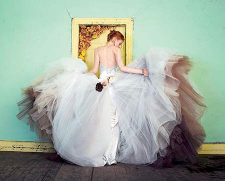 Chiếc váy cưới kiểu “nàng tiên cá” bằng satin màu ngà với phần thân trên được trang trí đá quý, phần tùng váy kết hợp với voan có sắc xám mờ, chuyển màu như một bức tranh màu nước, tạo cảm giác mờ ảo như khói sương, rất khó nắm bắt. Chiếc váy là thiết kế của nhà tạo mẫu Victor Harper.