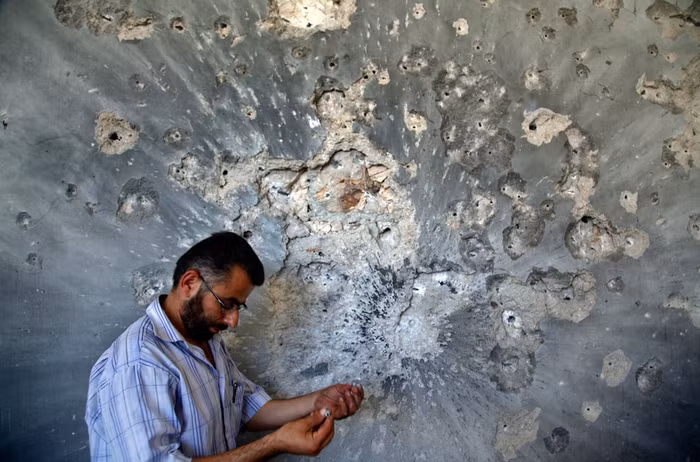 Một người đàn ông Syria đang cầm trên tay các vỏ đạn ở Aleppo, Syria ngày 5/8/2012