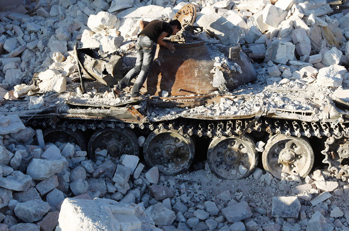 Một người đàn ông Syria đang ngó vào một chiếc xe tăng của quân chính phủ bị bắn hỏng ở Azaz hôm 3/8 Một người đàn ông Syria đang ngó vào một chiếc xe tăng của quân chính phủ bị bắn hỏng ở Azaz hôm 3/8
