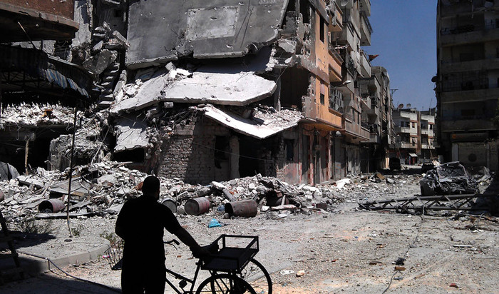 Một người đàn ông Syria đang đứng nhìn khu nhà bị đạn pháo oanh tạc ở Khaldiyeh, Homs, Syria, ngày 11/8,/2012 Một người đàn ông Syria đang đứng nhìn khu nhà bị đạn pháo oanh tạc ở Khaldiyeh, Homs, Syria, ngày 11/8,/2012