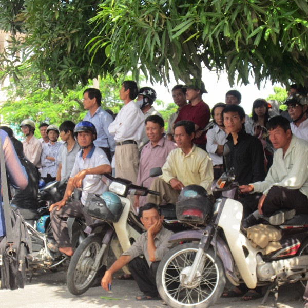 Kẻ đứng, người ngồi lo lắng cho những đứa con của mình đang làm bài trong phòng thi. (Xem đáp án môn Vật lí - Xem đáp án môn Toán)