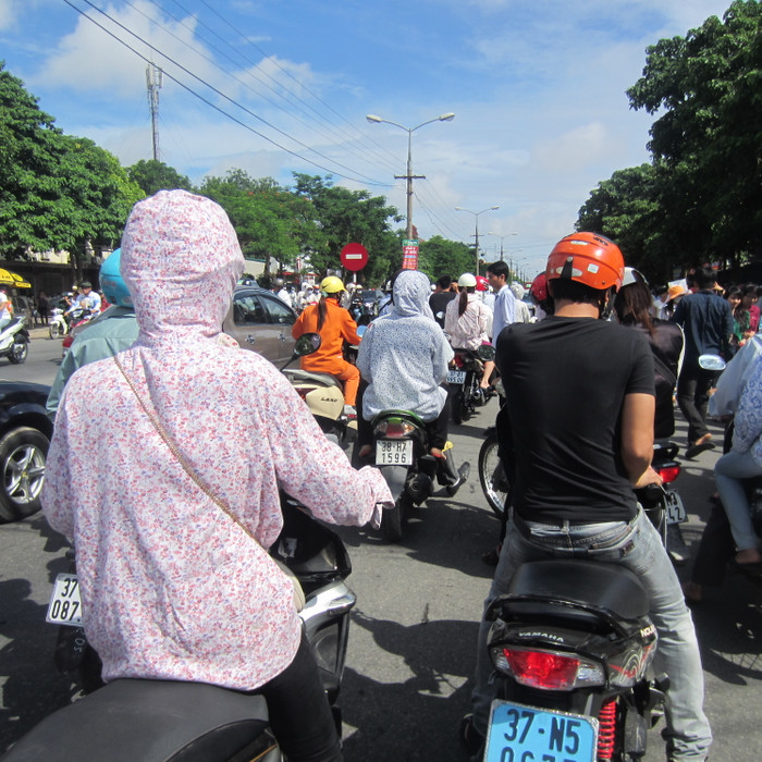 Các phụ vất vả len lỏi giữa dòng xe ùn tắc và nắng nóng để đưa con mình về nơi nghỉ ngơi chuẩn bị cho buổi thi tiếp theo.