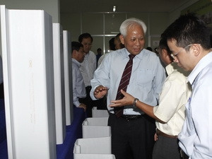 Các đại biểu thảo luận về cọc vách nhựa uPVC chống ngập úng, sạt lở bên lề hội thảo. (Ảnh: Hoàng Hải/Vietnam+)