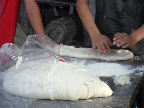 Bột làm quẩy đã được nhào nặn sẵn để trên bàn, cùng với đó là bột khô để ngay cạnh nhằm mục đích làm "phụ gia". Bột làm quẩy đã được nhào nặn sẵn để trên bàn, cùng với đó là bột khô để ngay cạnh nhằm mục đích làm "phụ gia".