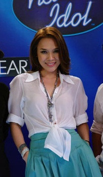 Áo sơ mi kết hợp với váy xanh trông Mỹ Tâm trẻ hơn tuổi rất nhiều.