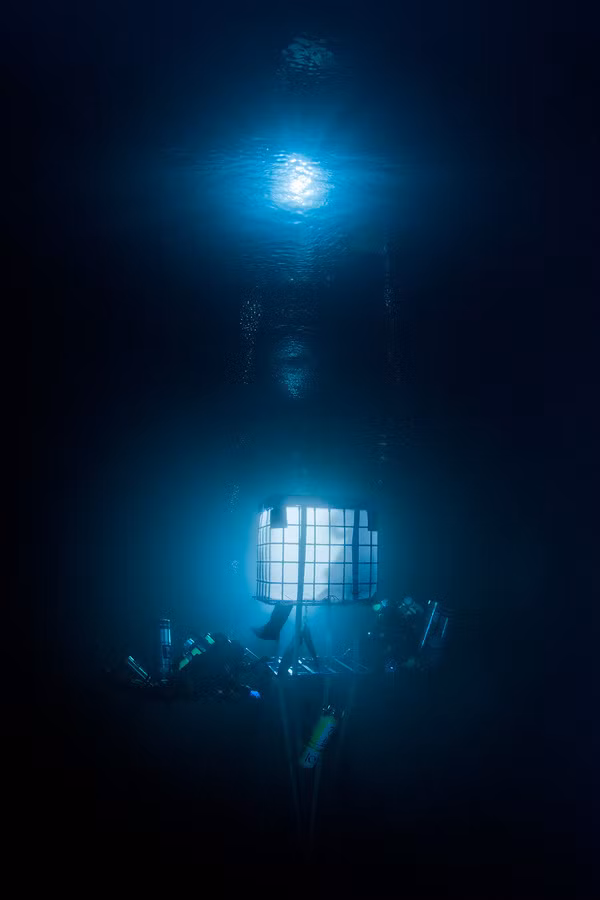 Một chiếc lồng an toàn dành cho các thợ lặn trong bóng tối đen đặc dưới vùng nước sâu của hồ Goluboe.