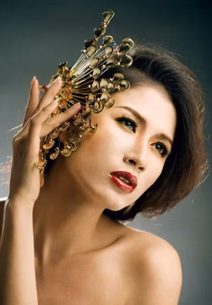 Trang Trần có vẻ đẹp bí ẩn Á đông khi kết hợp phấn mắt màu vàng đồng với son đỏ đậm.