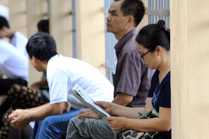 Tranh thủ đọc báo "giết thời gian" trong lúc chờ con làm bài.