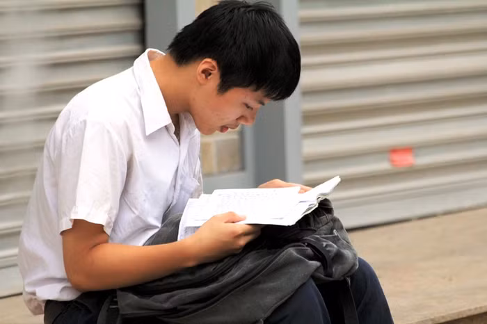 Đến sớm, nhiều thí sinh tranh thủ ôn lại bài trước khi vào phòng thi.