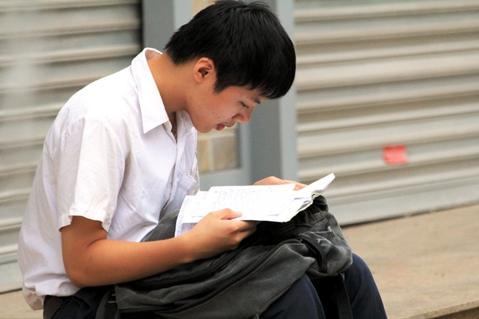 Đến sớm, nhiều thí sinh tranh thủ ôn lại bài trước khi vào phòng thi.