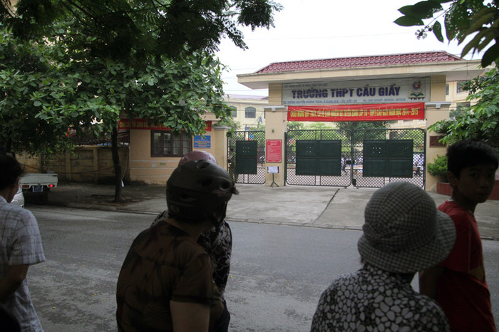 Những phụ huynh ngóng trông con bên ngoài cổng trường.