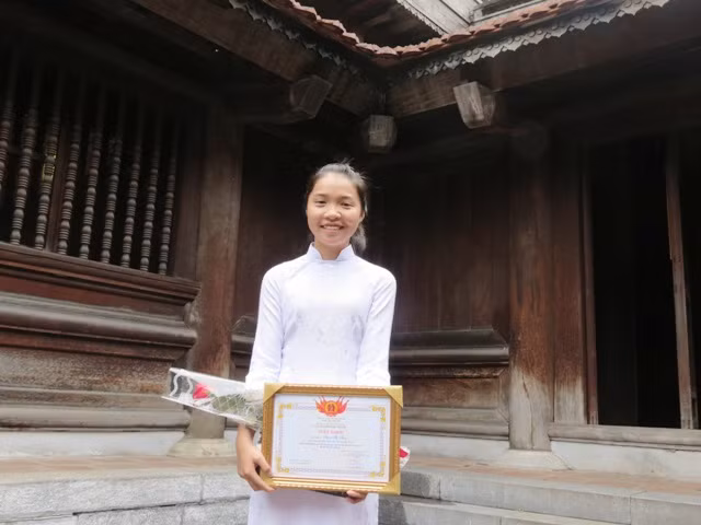 Em Phạm Thị Thùy, học sinh giỏi Sử Trường THPT chuyên Quảng Bình xúc động nhận giải thưởng trong buổi Lễ vinh danh học sinh giỏi Sử tại Văn Miếu Quốc Tử Giám. Ảnh Xuân Trung