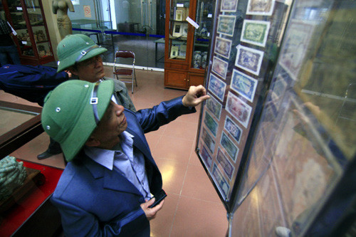 Người già ôn lại kỷ niệm với những đồng tiền cổ từ những thời kỳ khó khăn tại bảo tàng tỉnh Bắc Ninh.