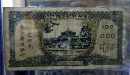 Đồng tiền mệnh giá một trăm đồng vàng được in bằng nhiều thứ tiếng.