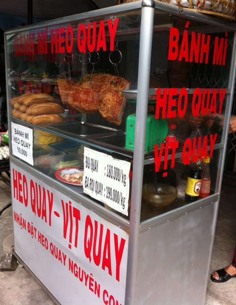 Bánh mỳ, thịt heo quay bán lẻ tại lề đường.