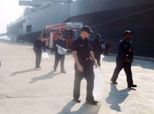 Các thuỷ thủ trên soái hạm USS Blue Ridge dàn hàng ngang nhặt rác trên cầu cảng Tiên Sa (Đà Nẵng) - Ảnh: HC
