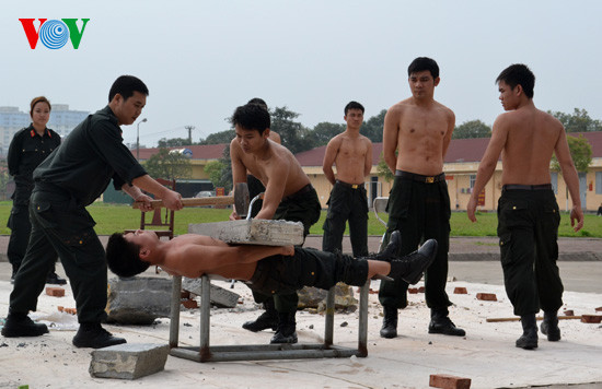 Chiến sĩ nằm thẳng trên 2 lưỡi của 2 thanh kiếm sắc, trên bụng đặt tảng bê tông Chiến sĩ nằm thẳng trên 2 lưỡi của 2 thanh kiếm sắc, trên bụng đặt tảng bê tông