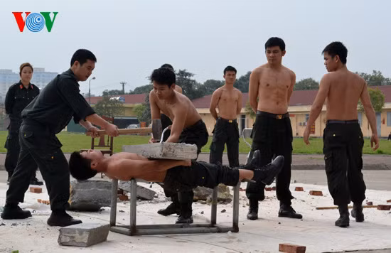 Chiến sĩ nằm thẳng trên 2 lưỡi của 2 thanh kiếm sắc, trên bụng đặt tảng bê tông