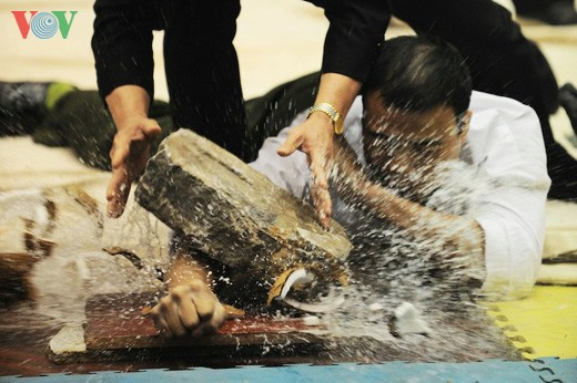 Kê tay lên quả dừa cứng rồi lấy đá gè lên.