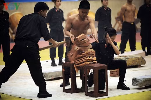 Nữ cảnh sát cơ động kê tay lên gạch và cho búa đập trực tiếp vào tay mình được hàng trăm khán giả tại Nhà thi đấu Bộ Công an hoan hô nhiệt liệt.