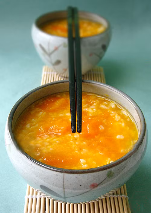 2. Cháo bí đỏ: Cháo bí đỏ nấu với đậu xanh, gạo nếp rất bổ dưỡng, giàu vitamin làm đẹp da và tóc. Món này thích hợp cho bữa ăn sáng hoặc ăn nhẹ buổi chiều.