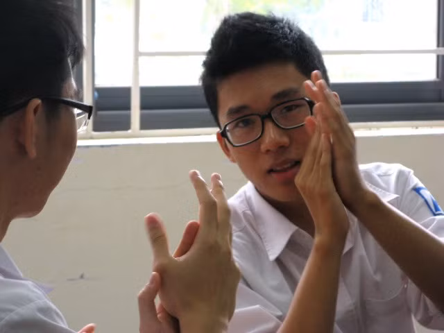 Các bạn cùng lớp vỗ tay chia sẻ niềm vui với Hiếu.