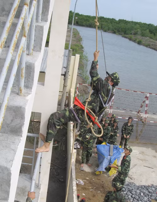 Đặc công đặc nhiệm đu đây vượt tường rào tấn công vào mục tiêu bị địch chiếm giữ - Ảnh: Q.LINH