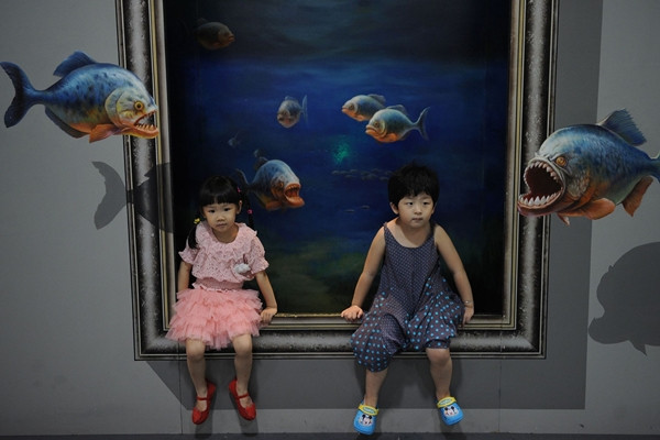 Hai em bé ngồi trong bể cá . Hai em bé ngồi trong bể cá .