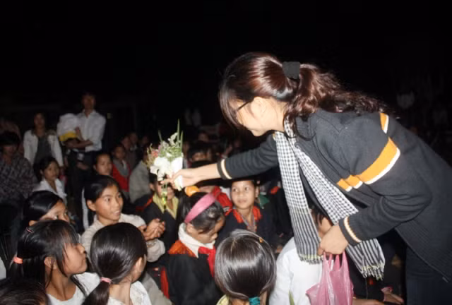 Mặc dù sương xuống ướt vai áo, nhưng Loan vẫn đi trao quà tận tay cho các em.