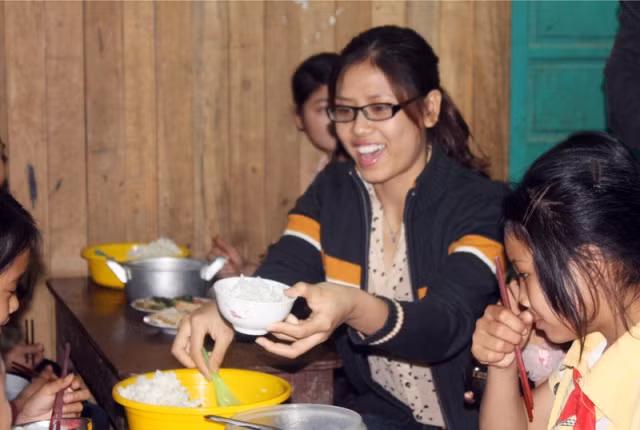 Loan cảm thấy rất vui khi tự tay xới cơm, chăm chút cho các em ăn.