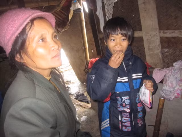 Chị Đặng Thị Hải cùng con trong ngôi lều tạm ngoài đồng. Ảnh XT