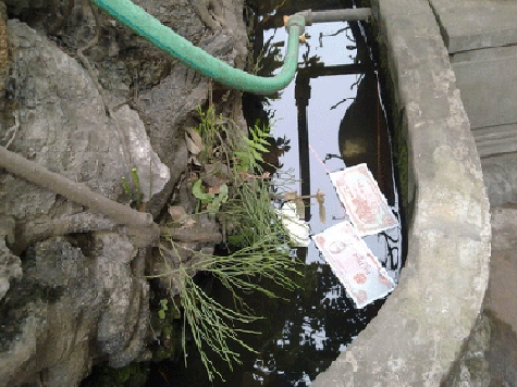 Tiền lẻ xuất hiện cả trong bể nước đá cảnh của chùa Hà. Tiền lẻ xuất hiện cả trong bể nước đá cảnh của chùa Hà.