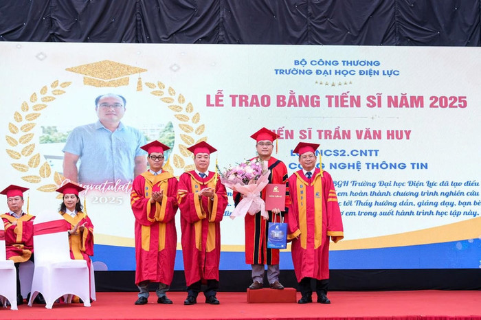 Phó Giáo sư, Tiến sĩ Vũ Đình Ngọ - Chủ tịch Hội đồng trường (thứ hai từ trái sang phải) và Phó Giáo sư, Tiến sĩ Đinh Văn Châu - Hiệu trưởng Trường Đại học Điện lực (ngoài cùng bên phải) trao bằng tốt nghiệp và chúc mừng tân tiến sĩ. Ảnh: EPU. 688b0f984116fe70239990ca.jpg