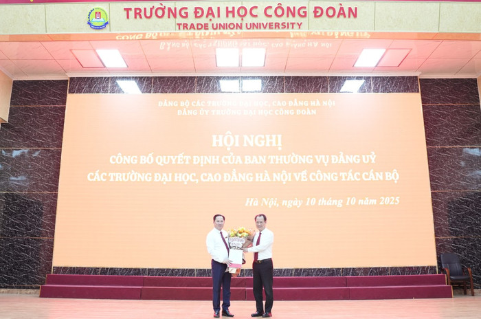 Đồng chí Nguyễn Thanh Sơn - Bí thư Đảng ủy các trường đại học, cao đẳng Hà Nội trao quyết định và tặng hoa cho đồng chí Lê Mạnh Hùng. Ảnh: NTCC. 41.png