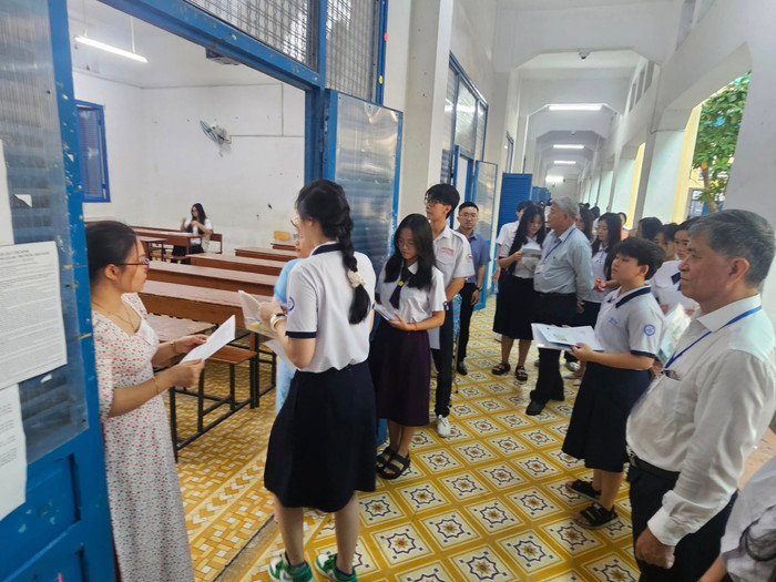 Cán bộ coi thi gọi tên thí sinh vào phòng thi ở điểm thi Trường Nguyễn Thị Diệu. Ảnh: V.D diemthintdc.jpg
