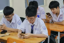 Học sinh Trường trung học phổ thông Bùi Thị Xuân làm bài kiểm tra trên máy tính, điện thoại tại lớp. Ảnh: NTCC.