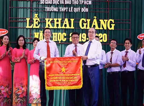Bí thư Nguyễn Thiện Nhân trao tặng cờ thi đua cho lãnh đạo Trường Lê Quý Đôn (ảnh: P.L)