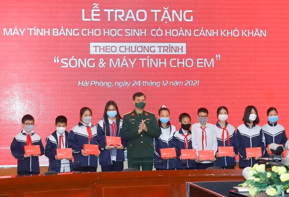 Đại tá Tào Đức Thắng – Phó Tổng Giám đốc Tập đoàn Công nghiệp – Viễn thông Quân đội trao tặng máy tính bảng cho các em học sinh có hoàn cảnh khó khăn (Ảnh: CTTĐT)