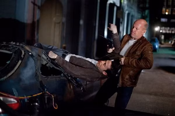 Nhân vật chính trong Loopers – Sát thủ vượt thời gian là Joe được hai nam diễn viên đảm nhiệm, Joseph Gordon-Levitt (tư thế nằm) trong vai Joe thời trẻ và nam tài tử Bruce Willis trong vai Joe tuổi trung niên. Vấn đề là Joe trẻ của Joseph Gordon-Levitt lại thuận tay trái trong khi Joe trung niên lại thuận tay phải. Có thể phân biệt qua bức ảnh trên. Ảnh. Sony Pictures.