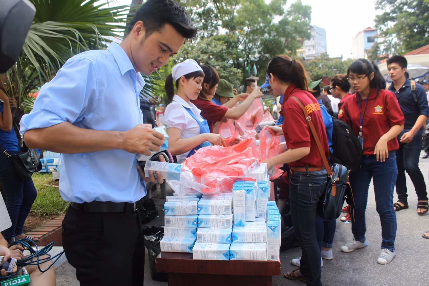 Nhân viên TH true MILK và các bạn tình nguyện trong nhóm Hương sen đại bi chùa Hưng Khánh chuẩn bị suất cơm trưa và sữa cho thí sinh và người nhà.