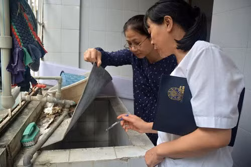 Cán bộ y tế hướng dẫn diệt bọ gậy, đảm bảo vệ sinh môi trường. ảnh: Hà Nội Mới.