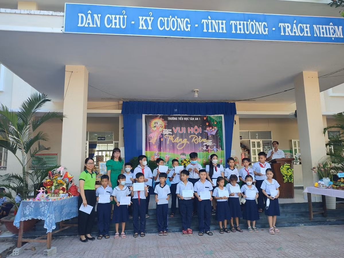 Đại diện doanh nghiệp trao bảo hiểm y tế cho học sinh có hoàn cảnh khó khăn. Ảnh minh họa bài viết: Phan Tuyết
