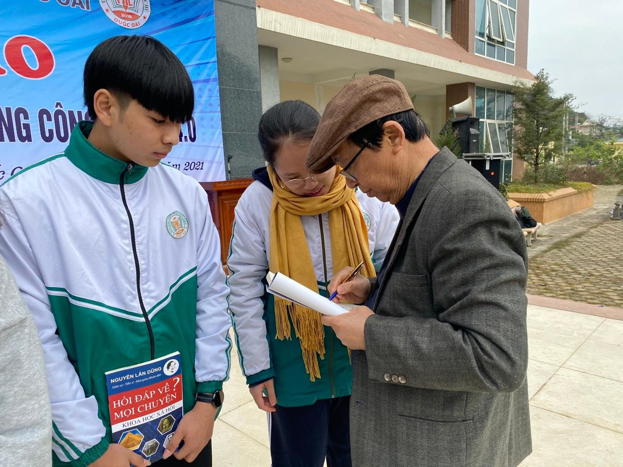 Giáo sư Nguyễn Lân Dũng ký tặng sach cho học sinh (Ảnh: Phạm Minh)
